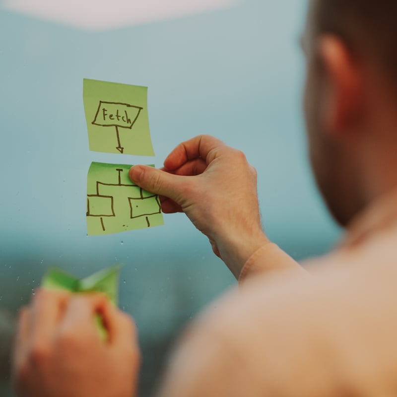 Man som hänger upp post-it lappar på väggen