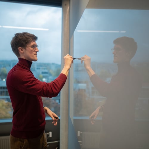 Person skriver på whiteboard