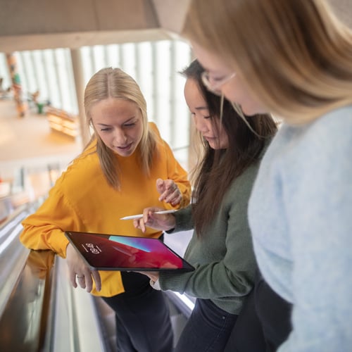 Tre personer kollar på iPad