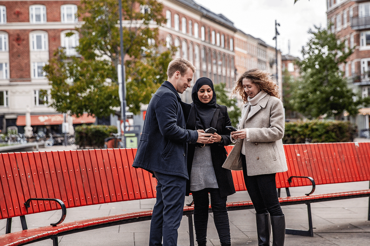 tre personer tittar i mobiler