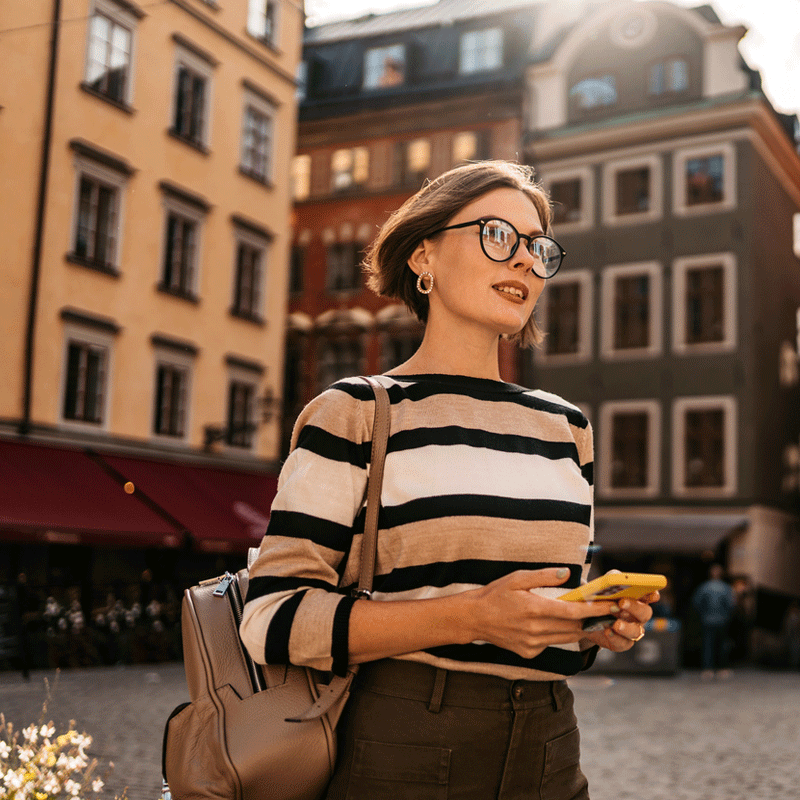 Kvinna i Stockholm som håller i en mobiltelefon